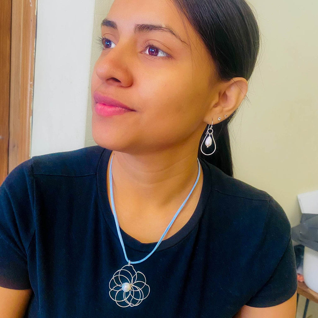 Petals silver flower and pearl pendant on a blue suede necklace