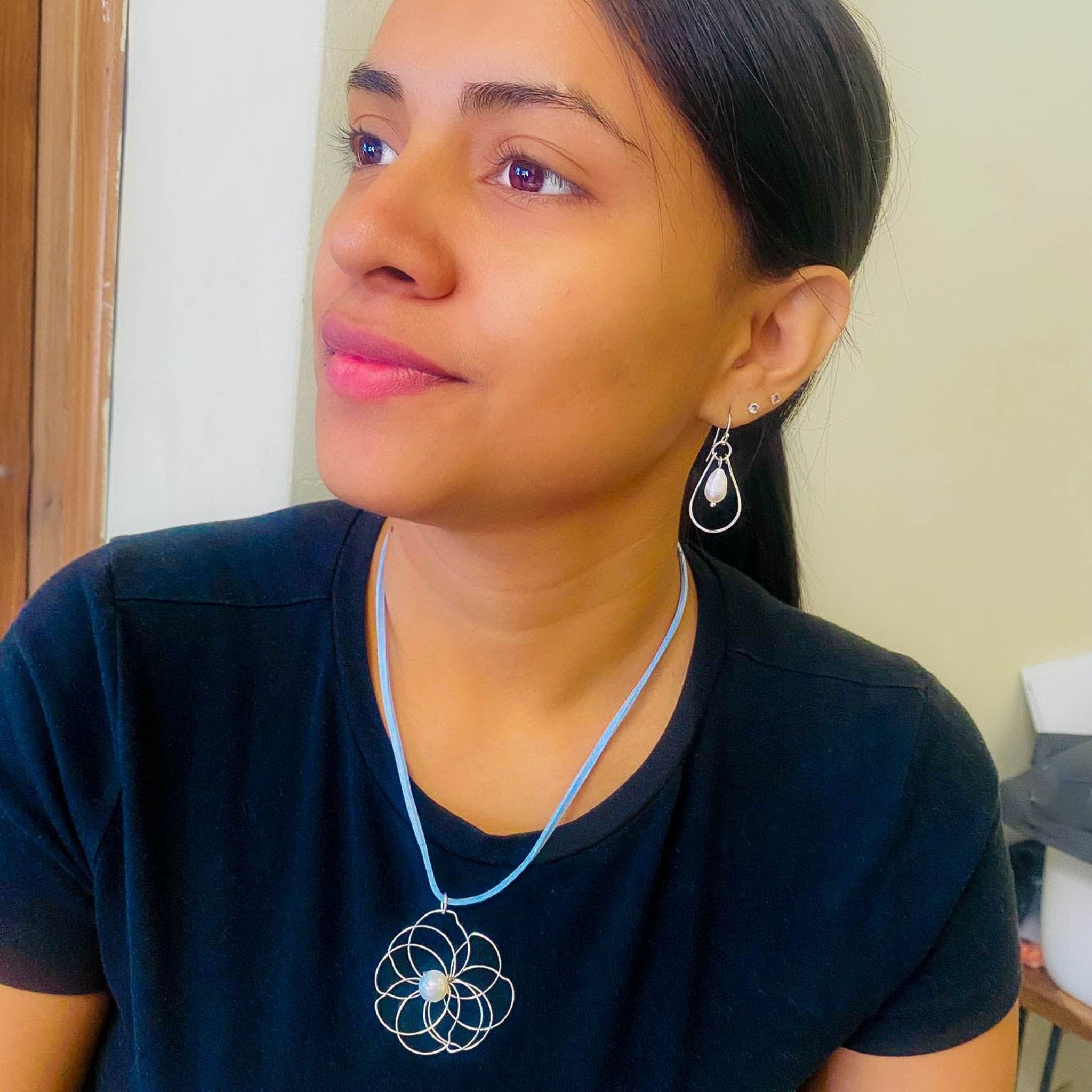 Petals silver flower and pearl pendant on a blue suede necklace